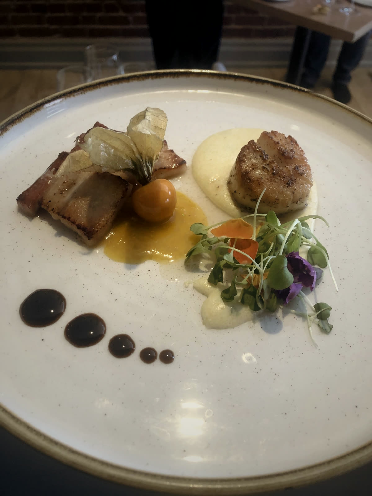 Seared scallop and pork belly plated fine-dining style with balsamic reduction