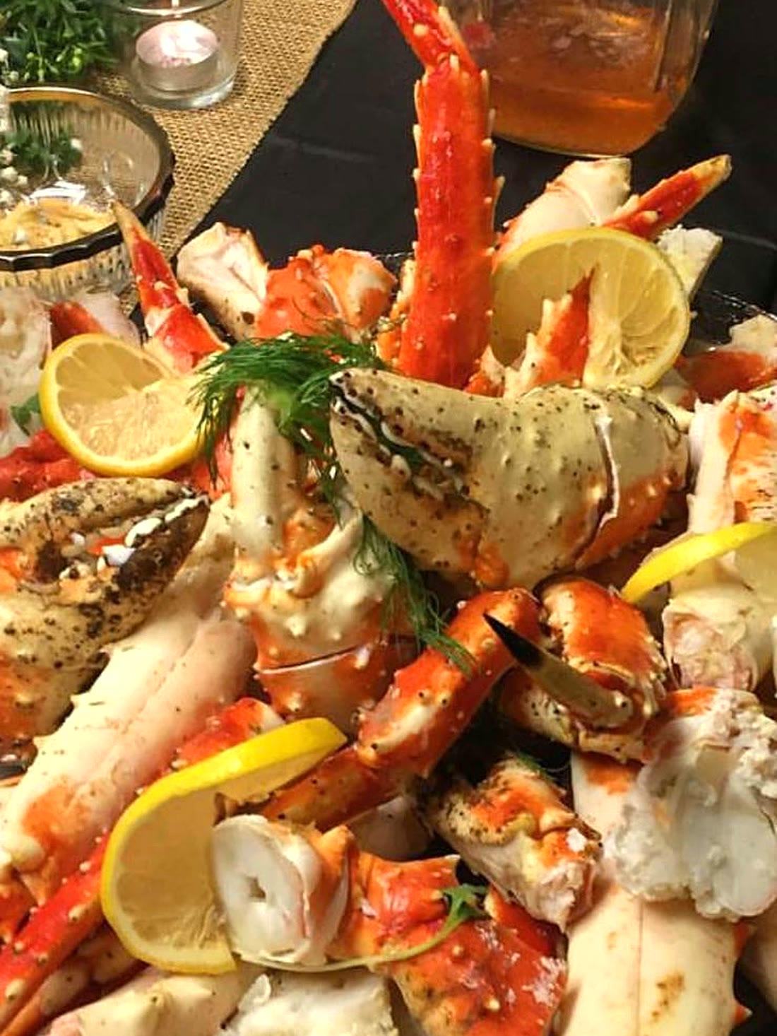 A heaping platter of king crab legs and claws with lemon and fresh dill from the Portuguese seafood buffet