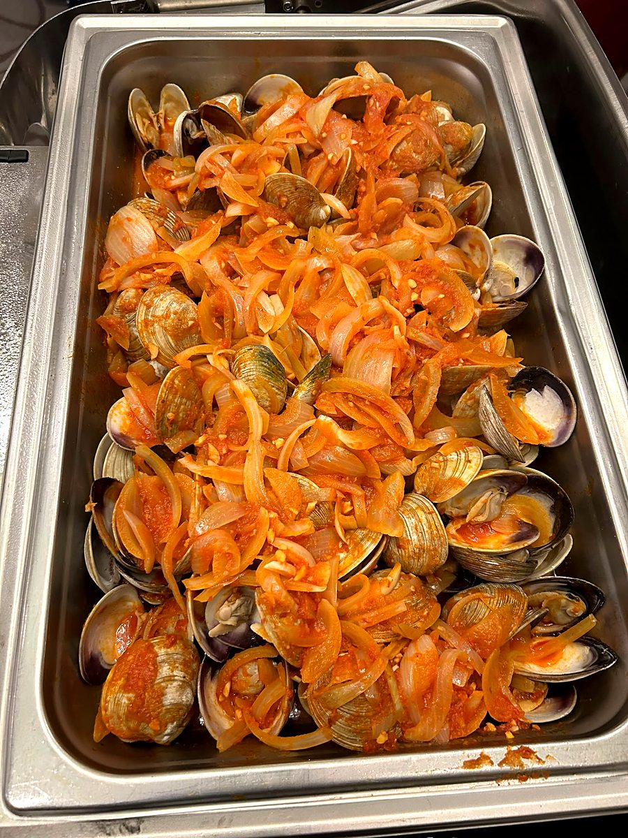 Clams simmered with onion and tomato in a chafing dish