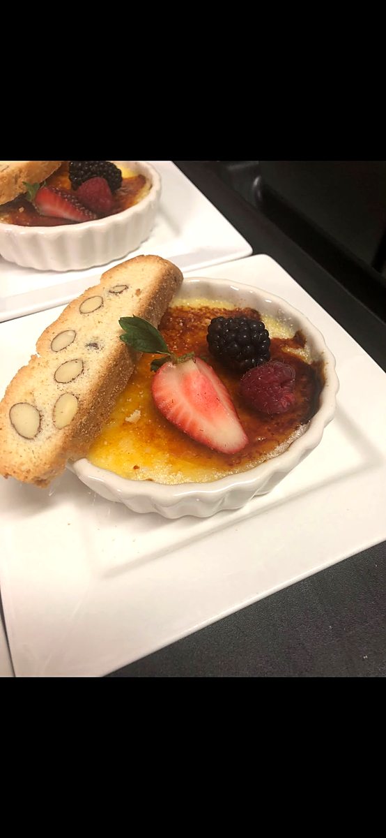 Creme brulee with fresh berries and biscotti, plated dessert