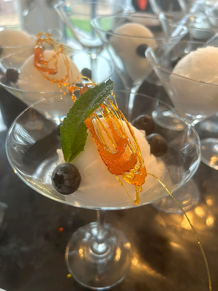 Plated dessert in a martini glass with spun sugar garnish