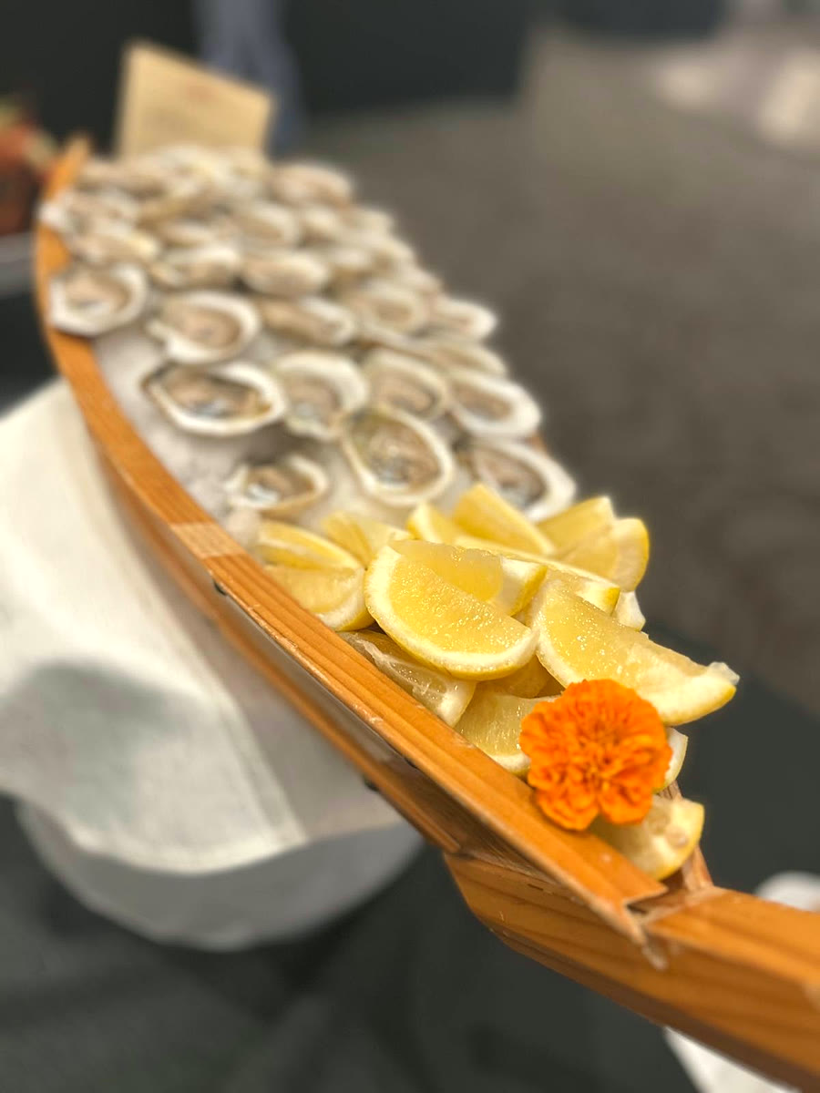 Oyster boat dressed with fresh lemon wedges and a marigold