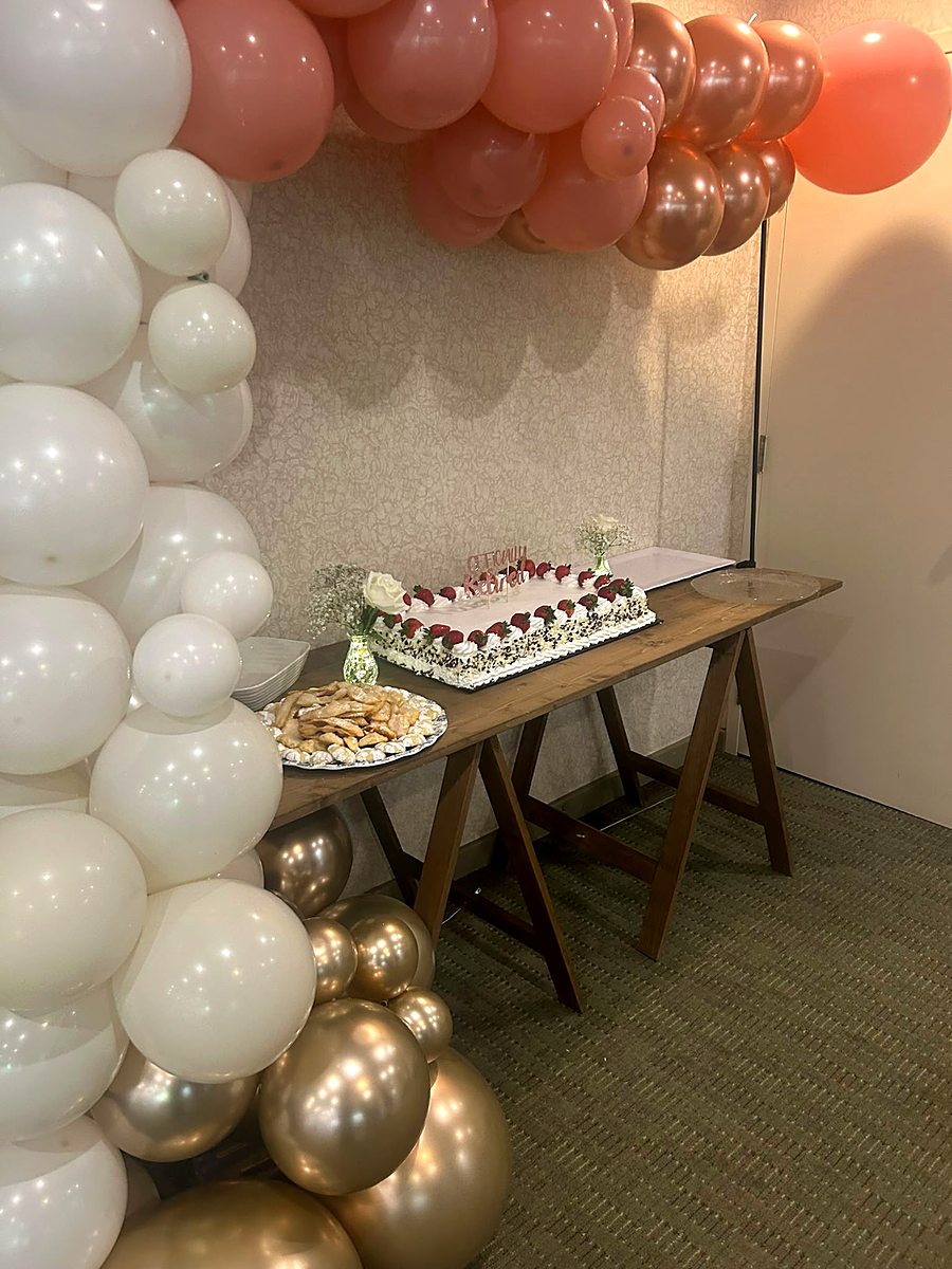 Dessert table with balloon arch styled for a baby shower