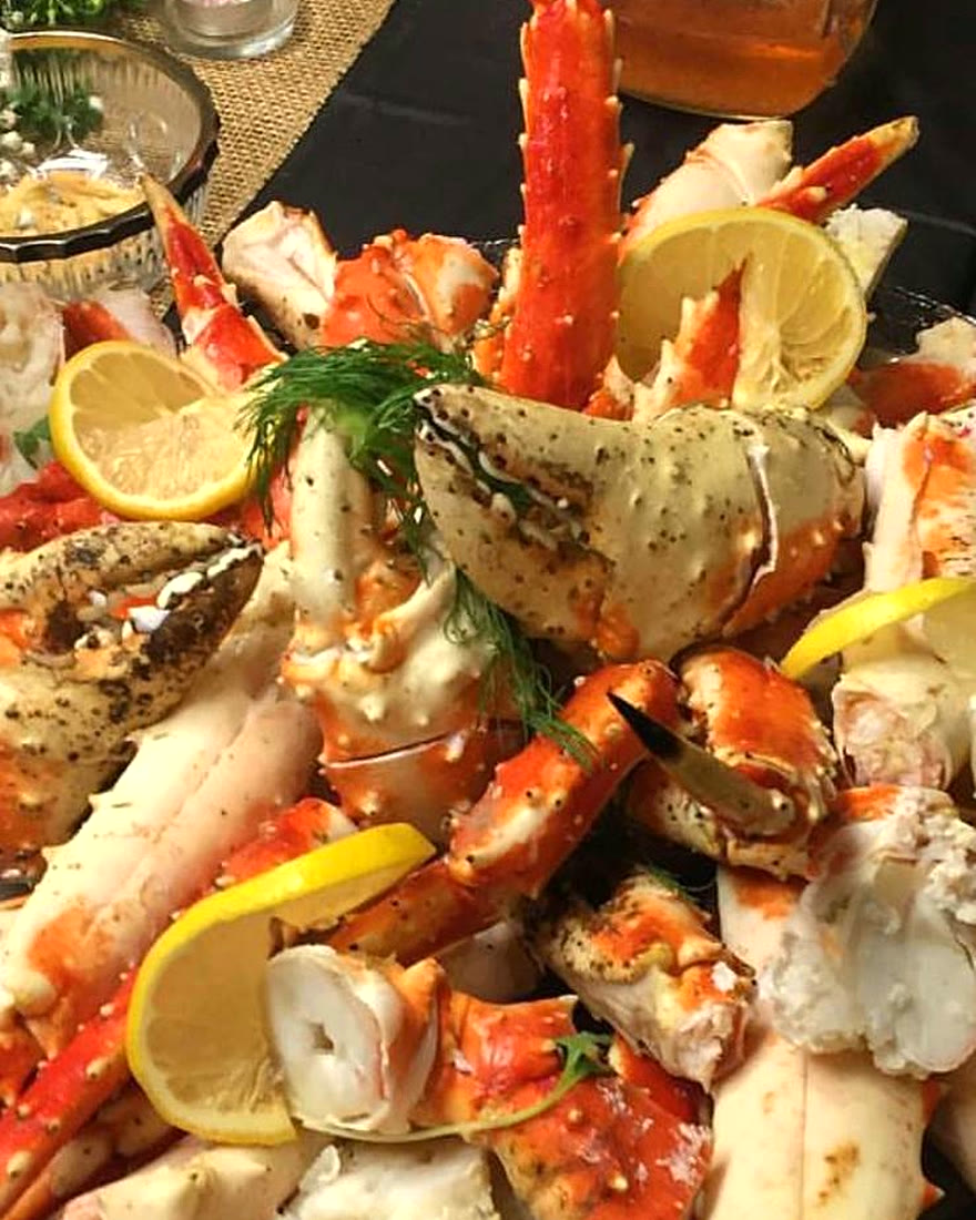 King crab legs and claws piled high with lemon and fresh dill from the CF Culinary Events seafood buffet