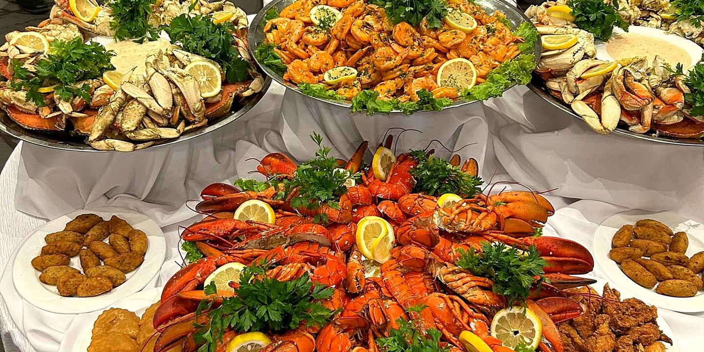 A full Portuguese seafood buffet table set by CF Culinary Events — lobster, crab and shrimp platters