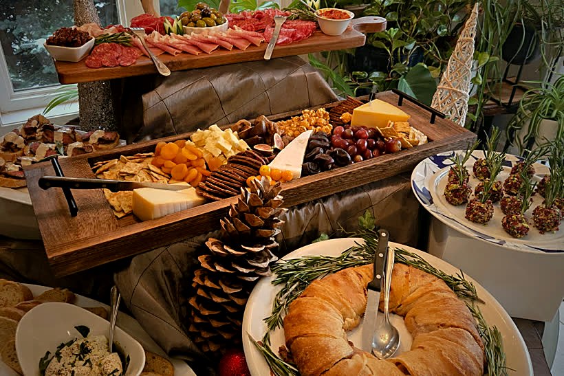 A lavish tiered grazing table of charcuterie, cheeses, breads and antipasto set for a full-service event