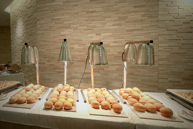 Trays of fresh malasadas under heat lamps at a CF Culinary Events live station