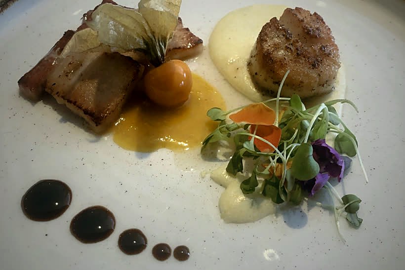 Seared scallop and pork belly plated fine-dining style with cauliflower purée and balsamic